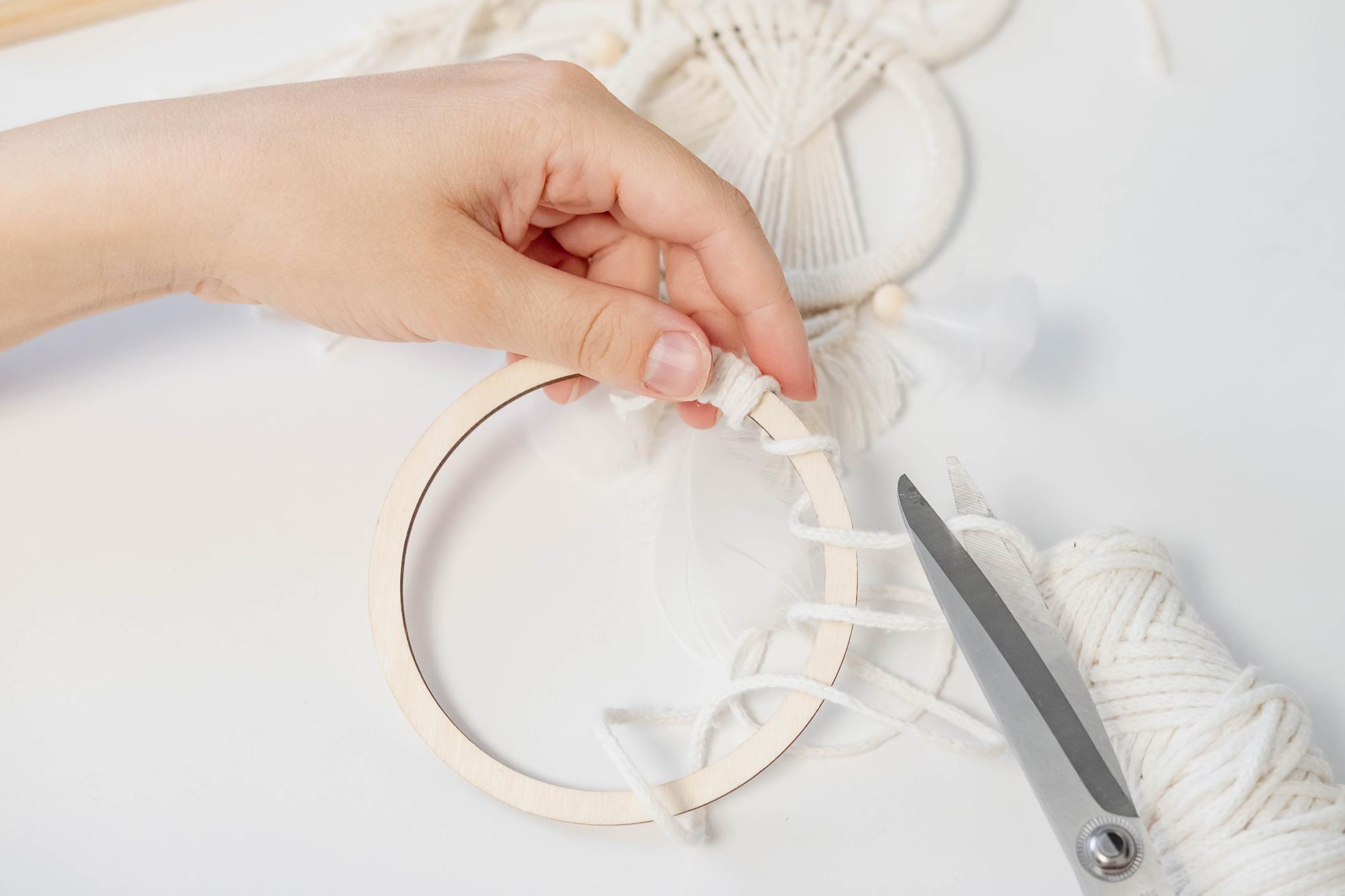 Hands threading an embroidery hoop