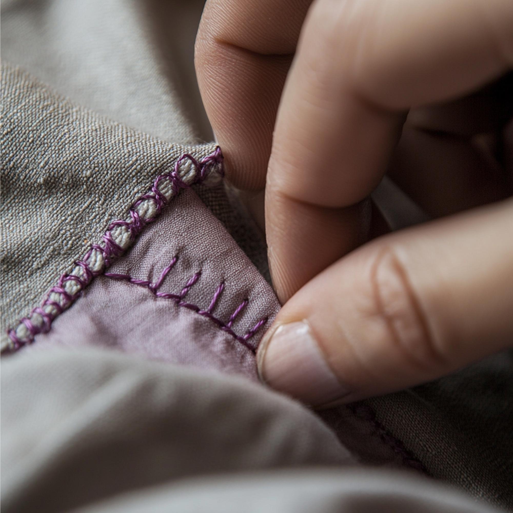 Close-up of hand embroidery on linen with muted palette